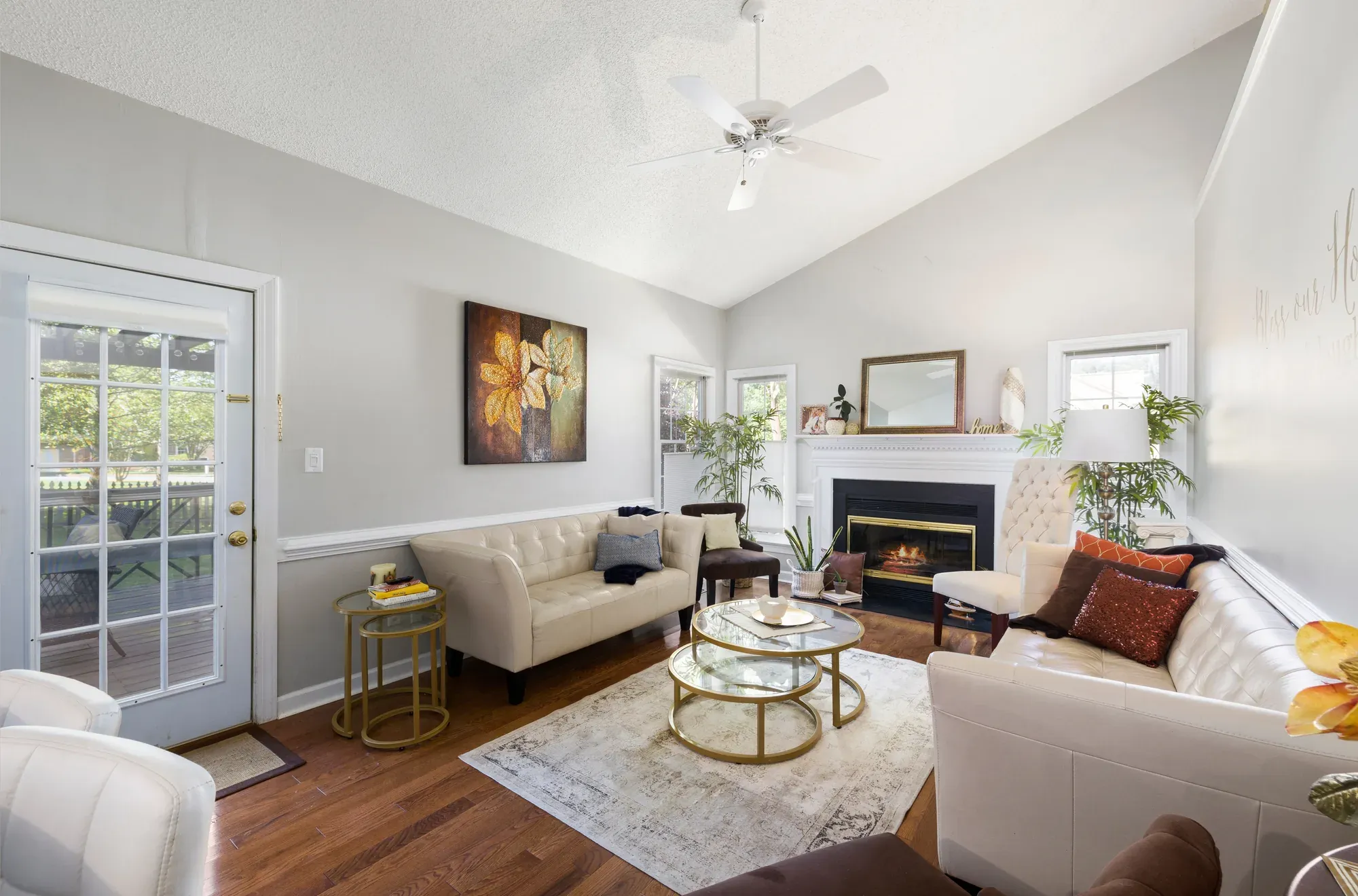 A finished living room with gray painted walls, white trim, a fireplace, sofas and a rug over wood flooring